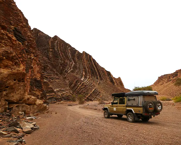 Guided 4x4 safari vehicle on a gravel road in Damaraland, Namibia